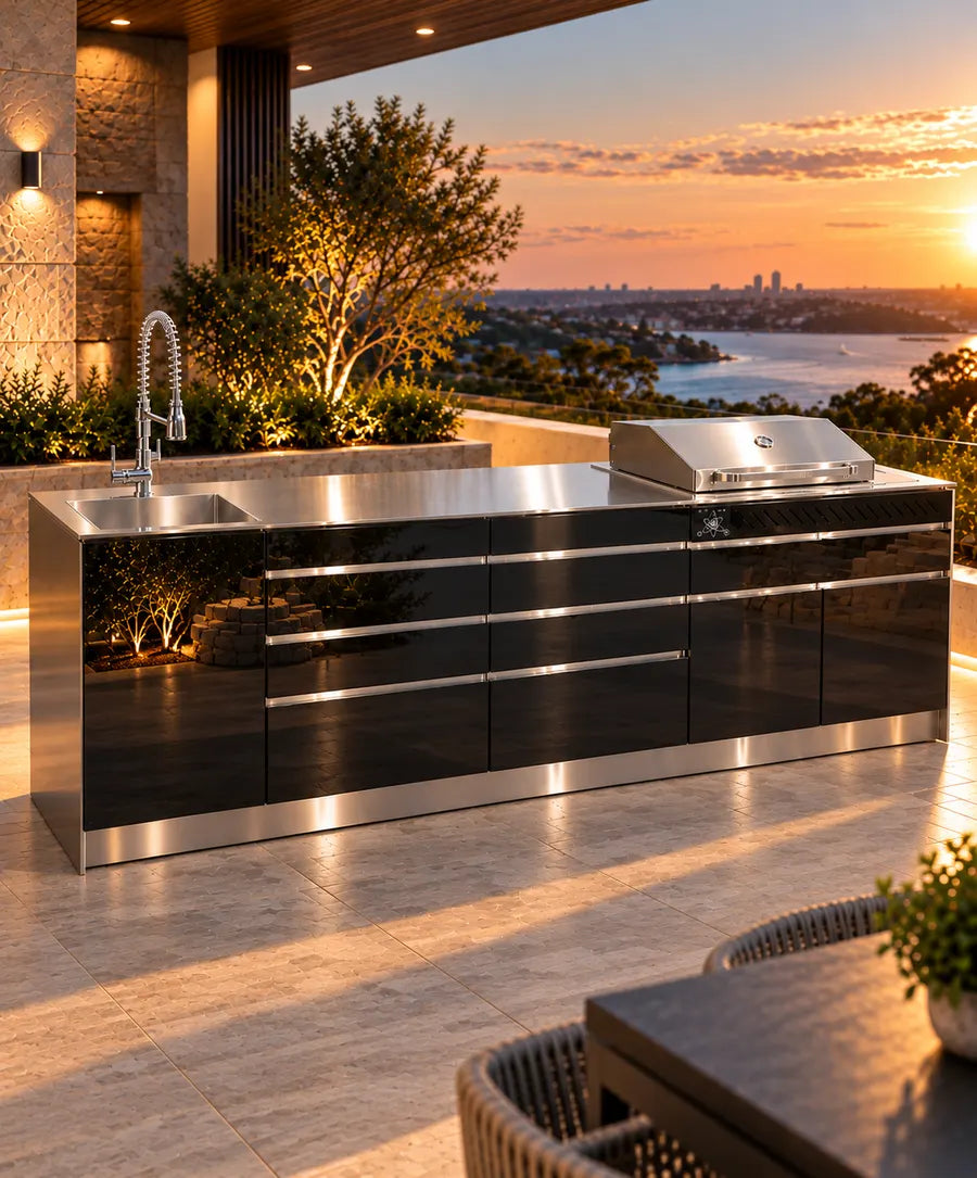 Black PVD outdoor kitchen with stainless benchtop, built-in BBQ and gooseneck tap overlooking the water