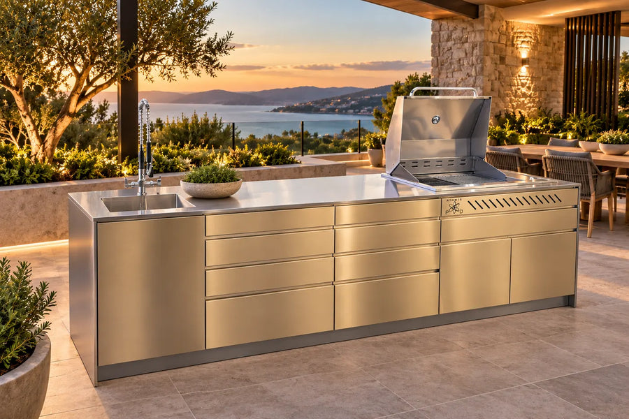 Champagne outdoor kitchen with built-in BBQ beside a pool at sunset
